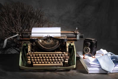 typewriter-with-stack-paper-and-glasses