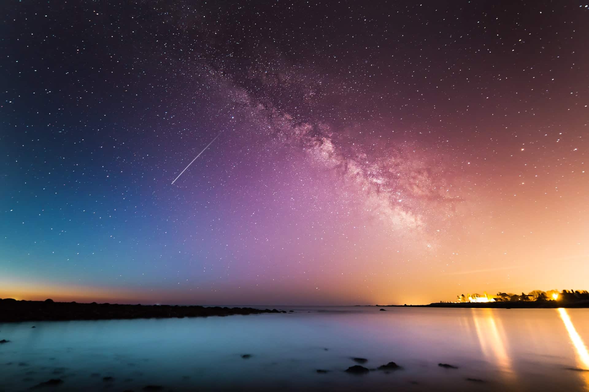 Stars in the sky and shooting star over water