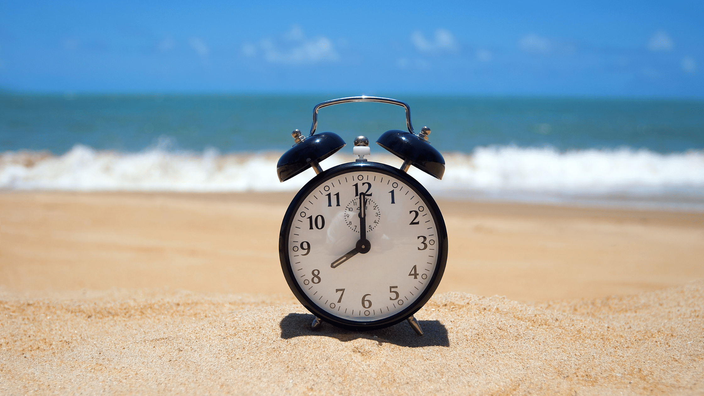 Clock Sitting On The Sand At A Beach